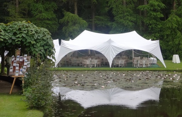 Beautiful wedding marquee set up beside a serene lake, featuring elegant decor and natural scenic views, ideal for picturesque outdoor weddings.