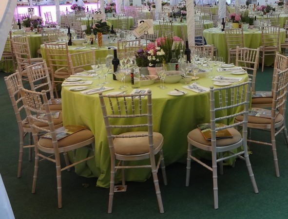 Lavish table setting inside a marquee at a millionaire's summer fest in Belgravia Square, London, featuring elegant decor and fine dining arrangements.
