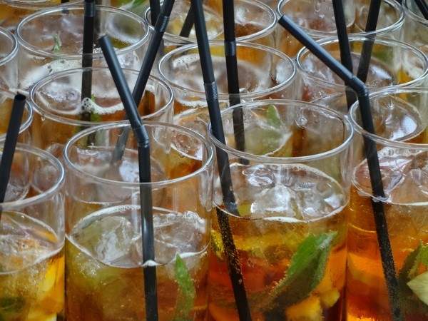 Close-up of several glasses of Pimm's, freshly prepared and ready to be served at a summer gathering.